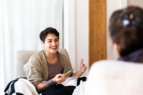 A person sitting in a chair, excitedly speaking to another person.